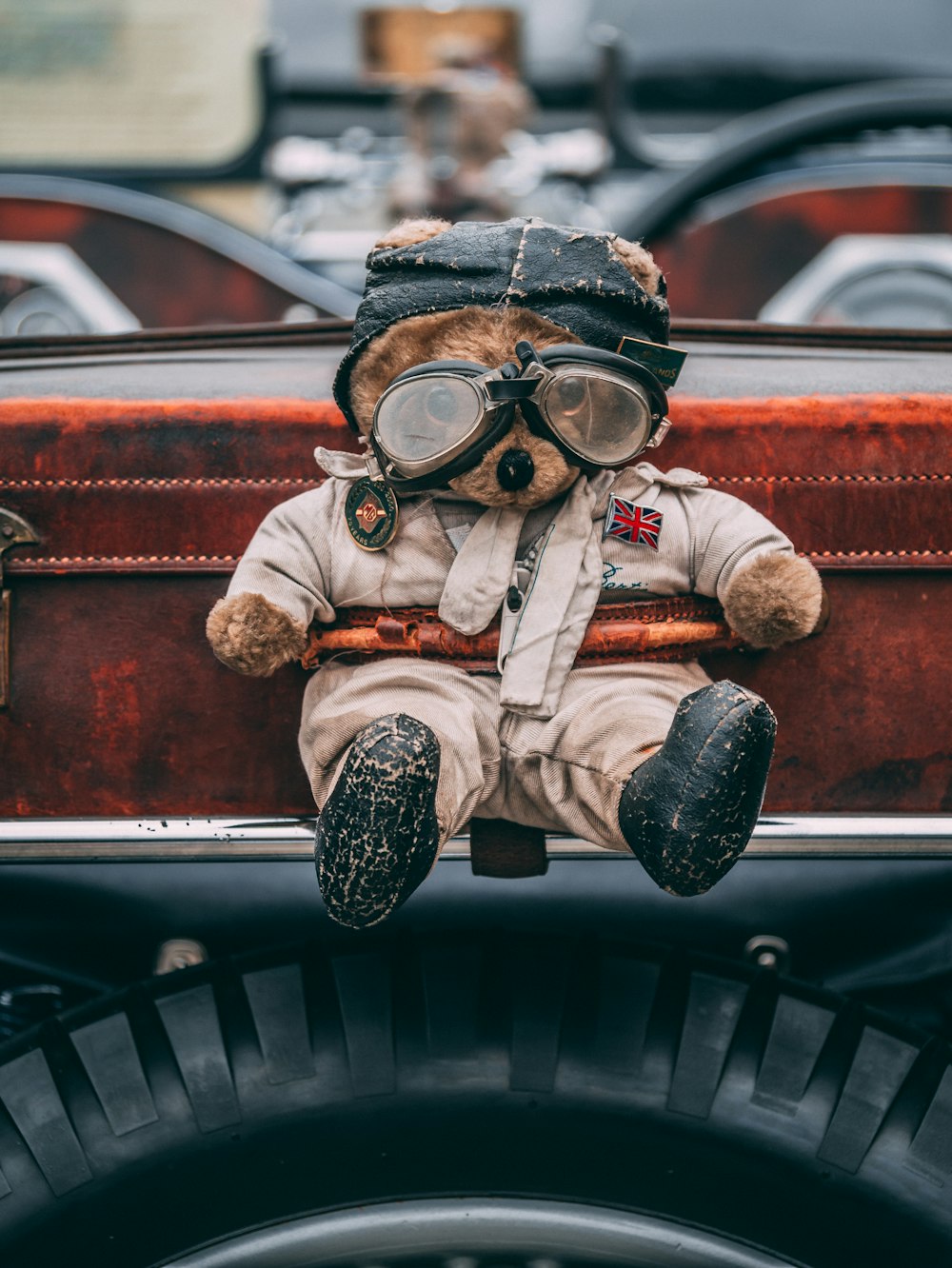 man in brown and white suit wearing goggles sitting on car