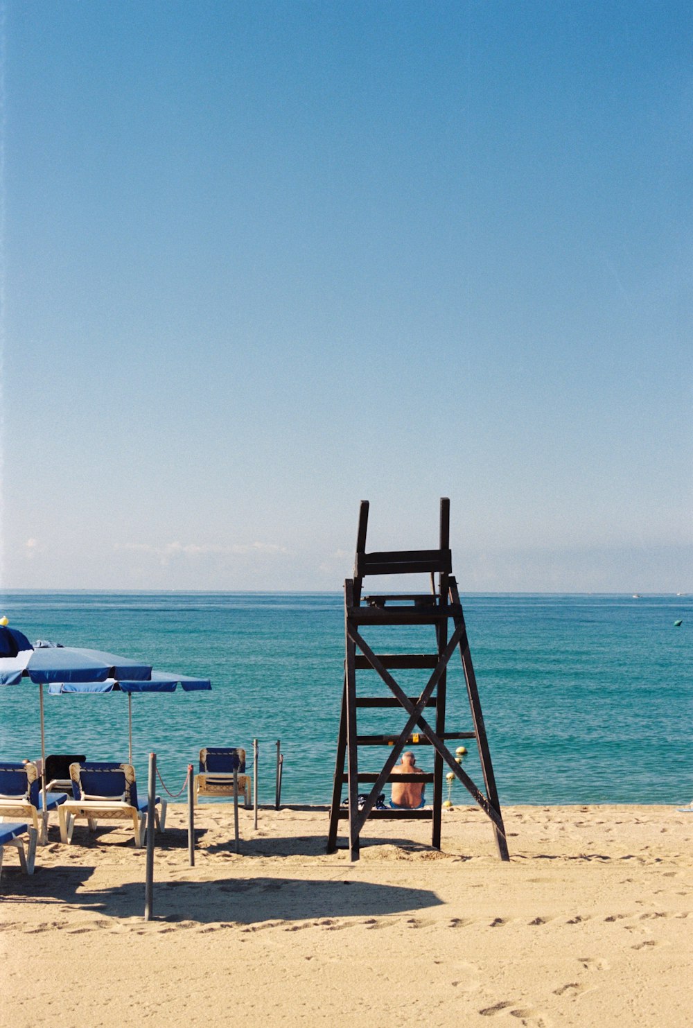 brown wooden lifeguard chair on beach during daytime