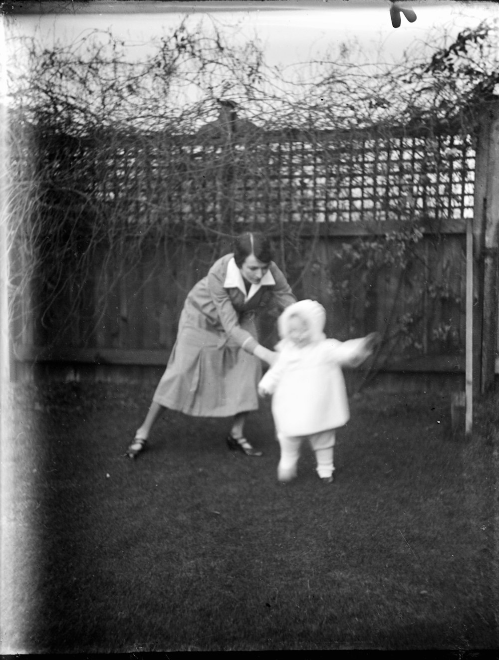 girl in white dress standing beside fence