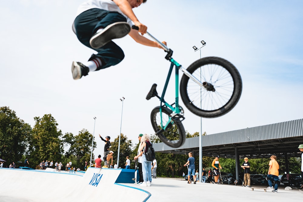 Mann im schwarzen Hemd fährt tagsüber auf grünem BMX-Fahrrad