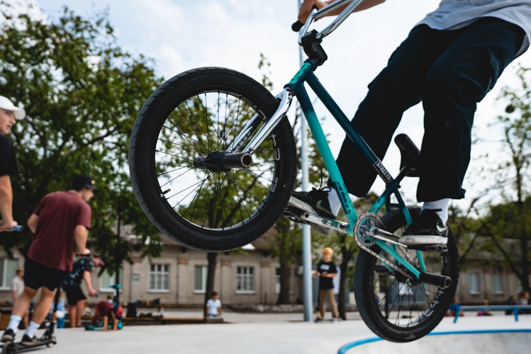 man in black jacket riding blue bicycle during daytime