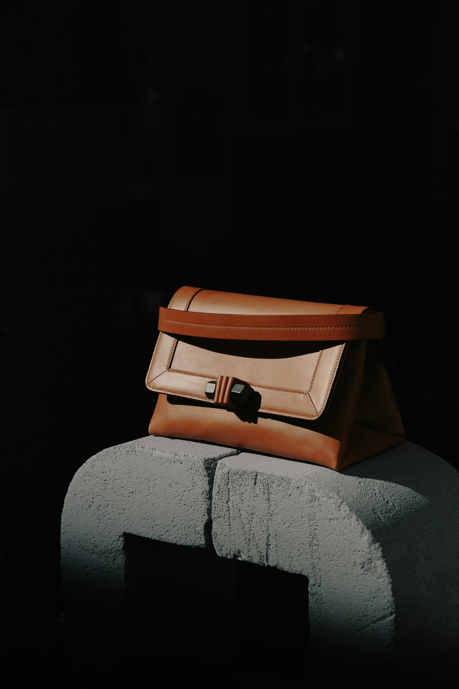 brown and black leather bag on gray textile