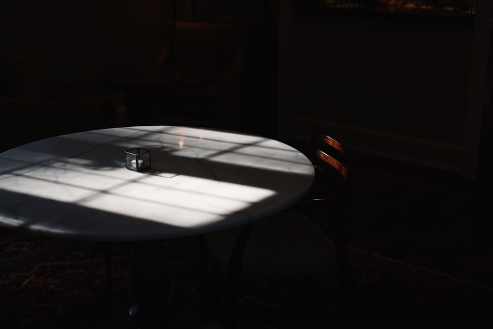 gafas de montura negra sobre mesa redonda blanca