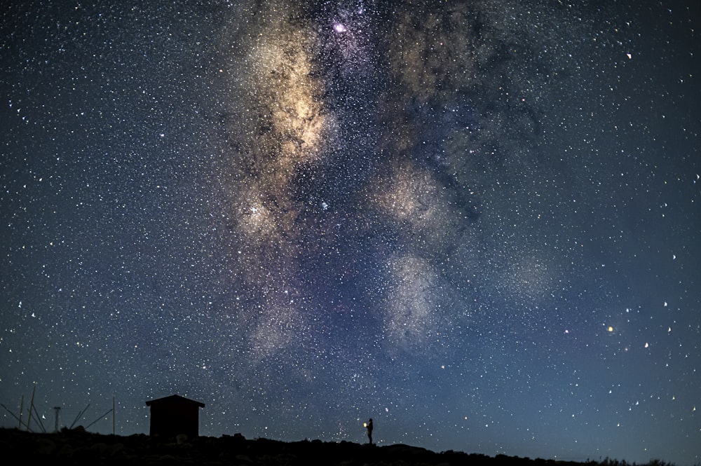 silhouette of house under starry night