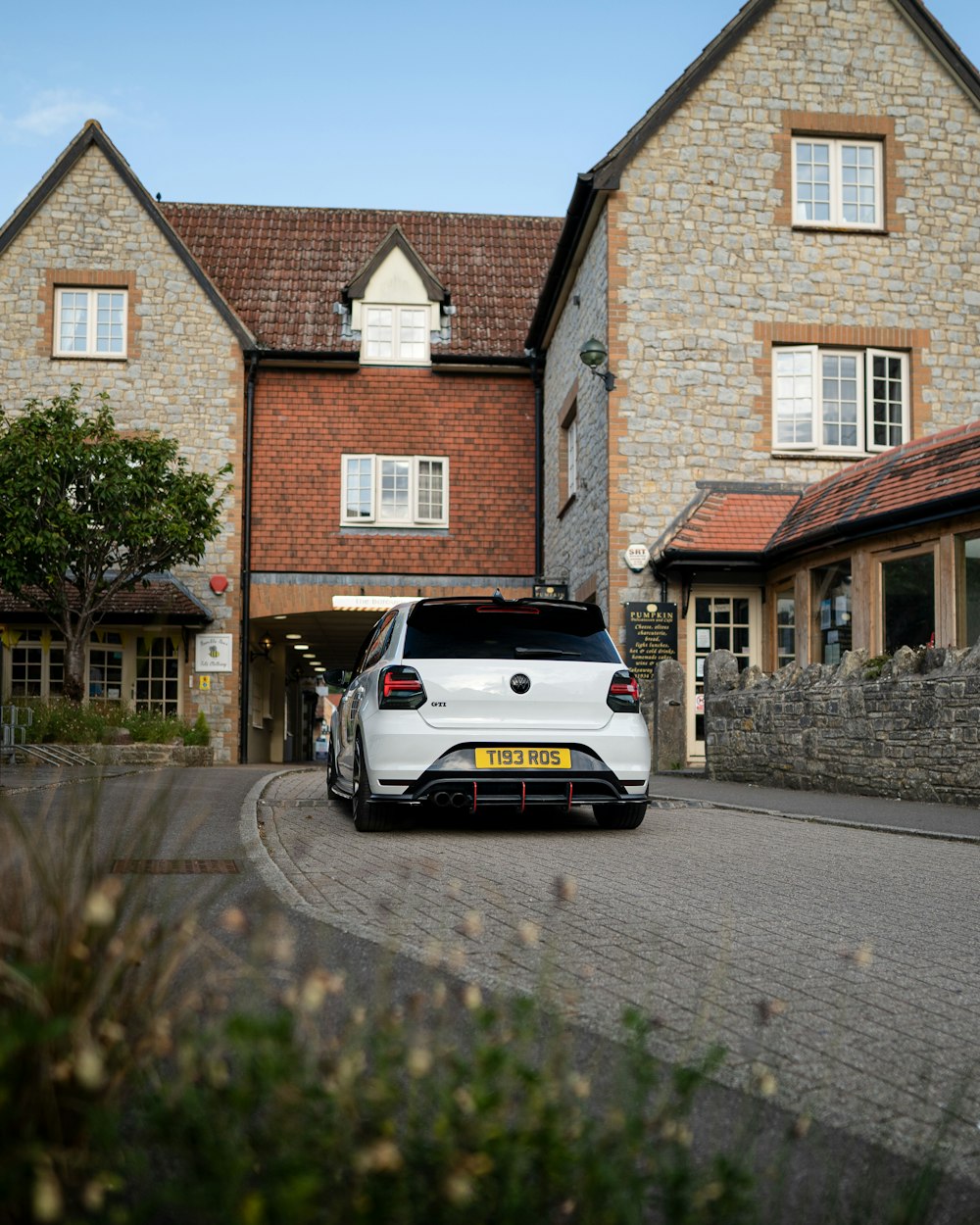 white car parked beside brown brick building