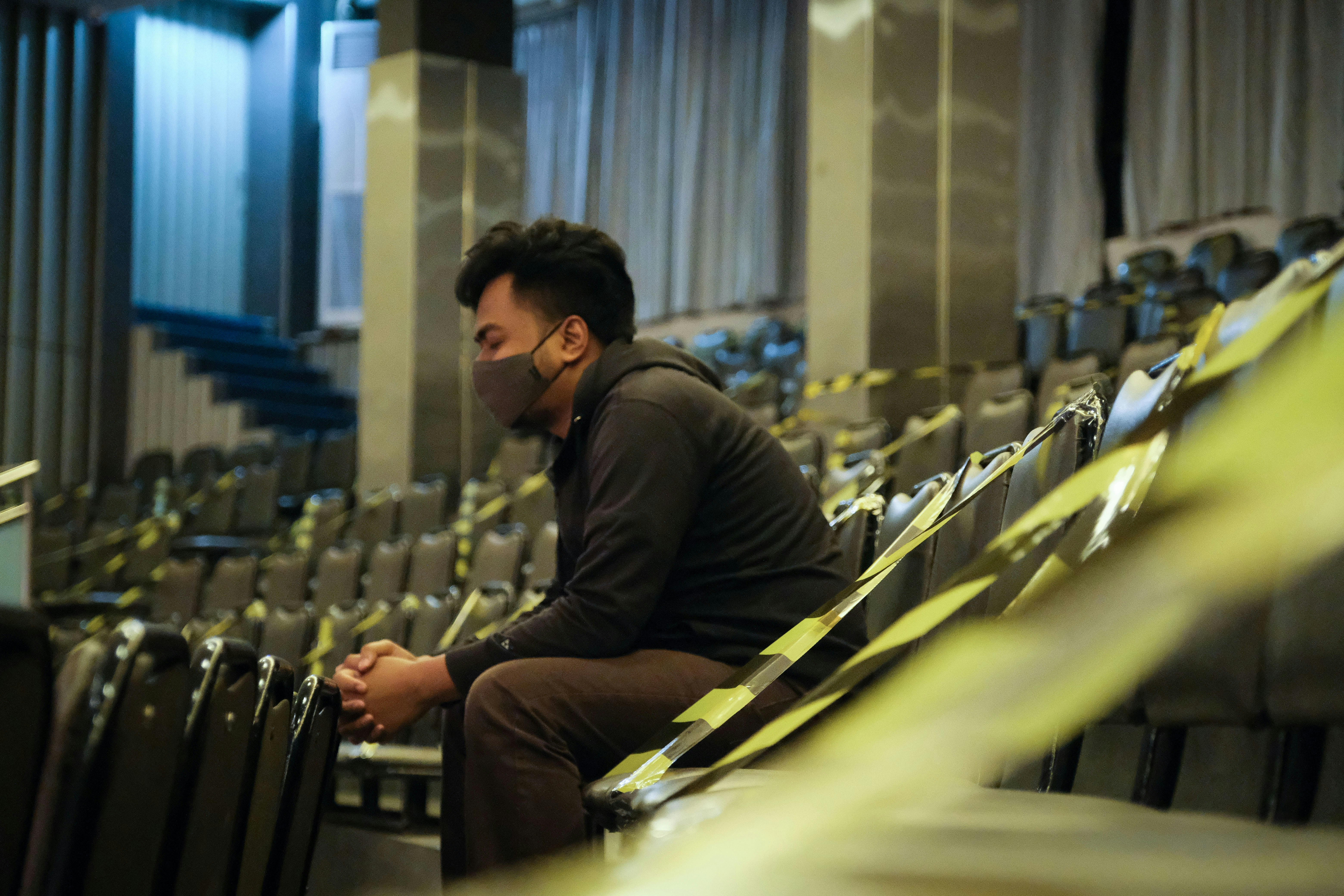 uomo in giacca nera che si siede sulla sedia