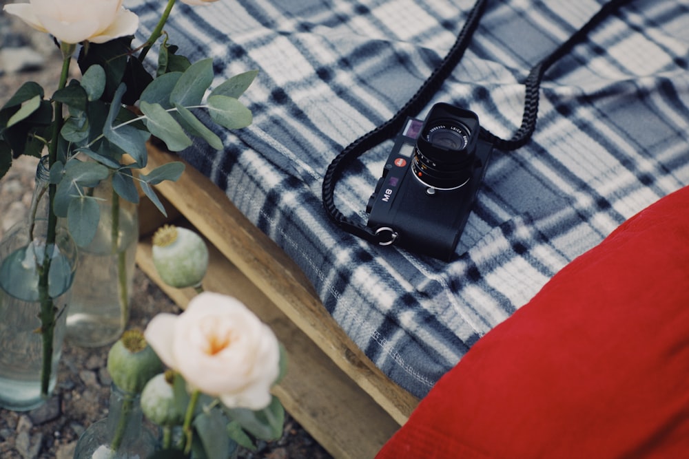 black dslr camera on blue and white floral textile