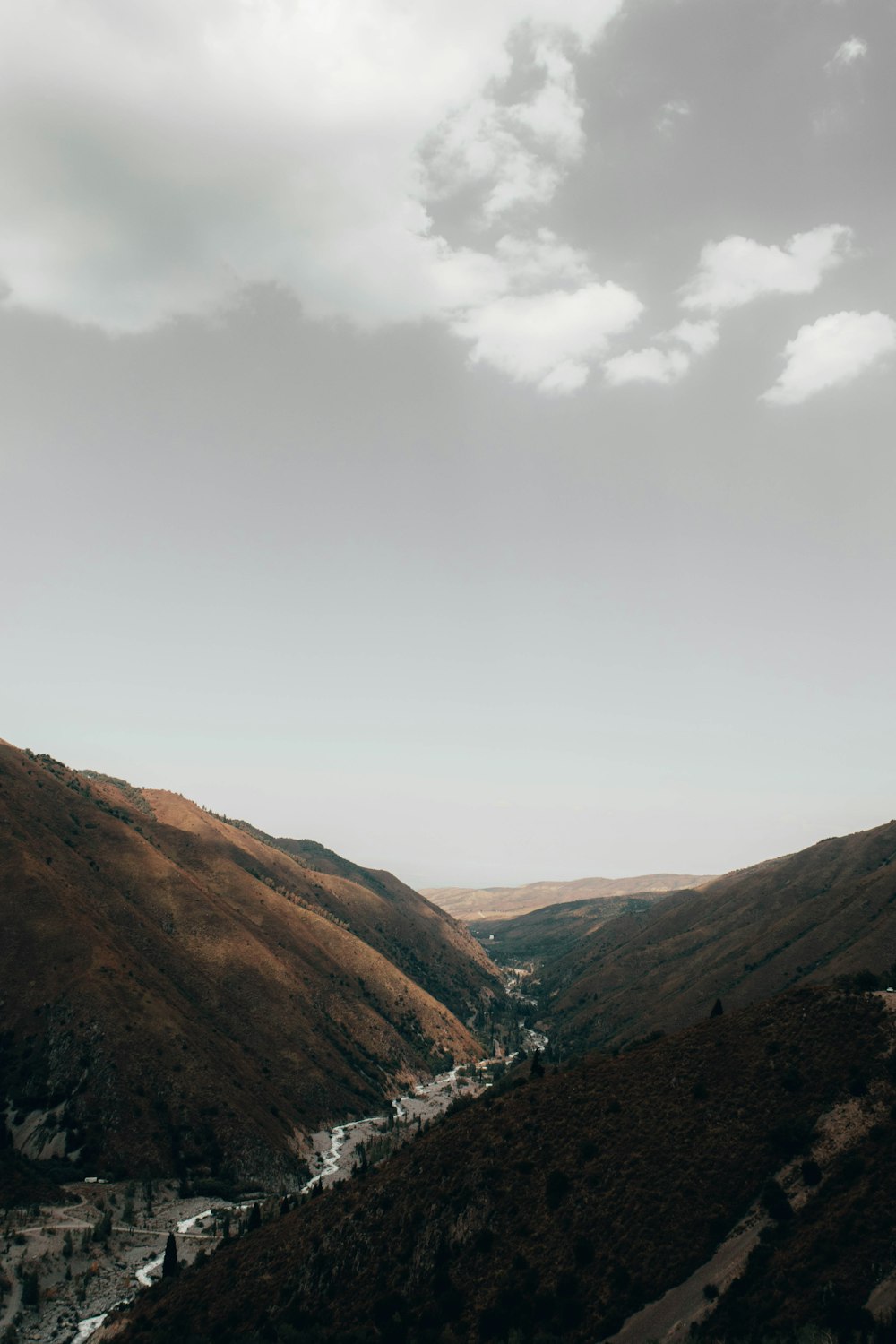 brown and green mountains under white clouds during daytime