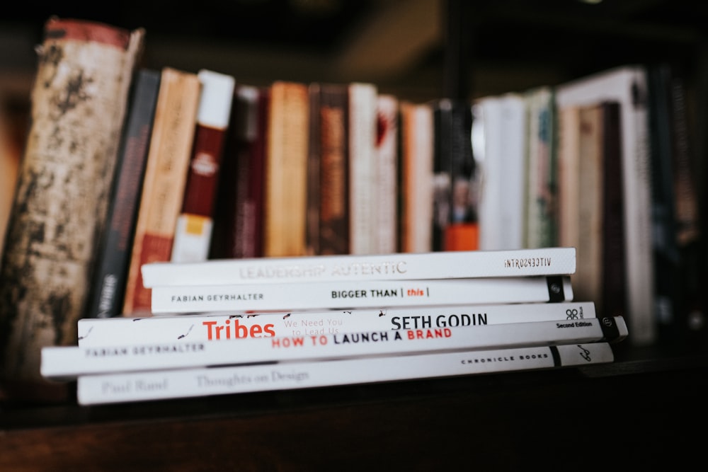 white and red books on brown wooden shelf