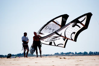 man and woman standing on brown sand near white and black ship during daytime