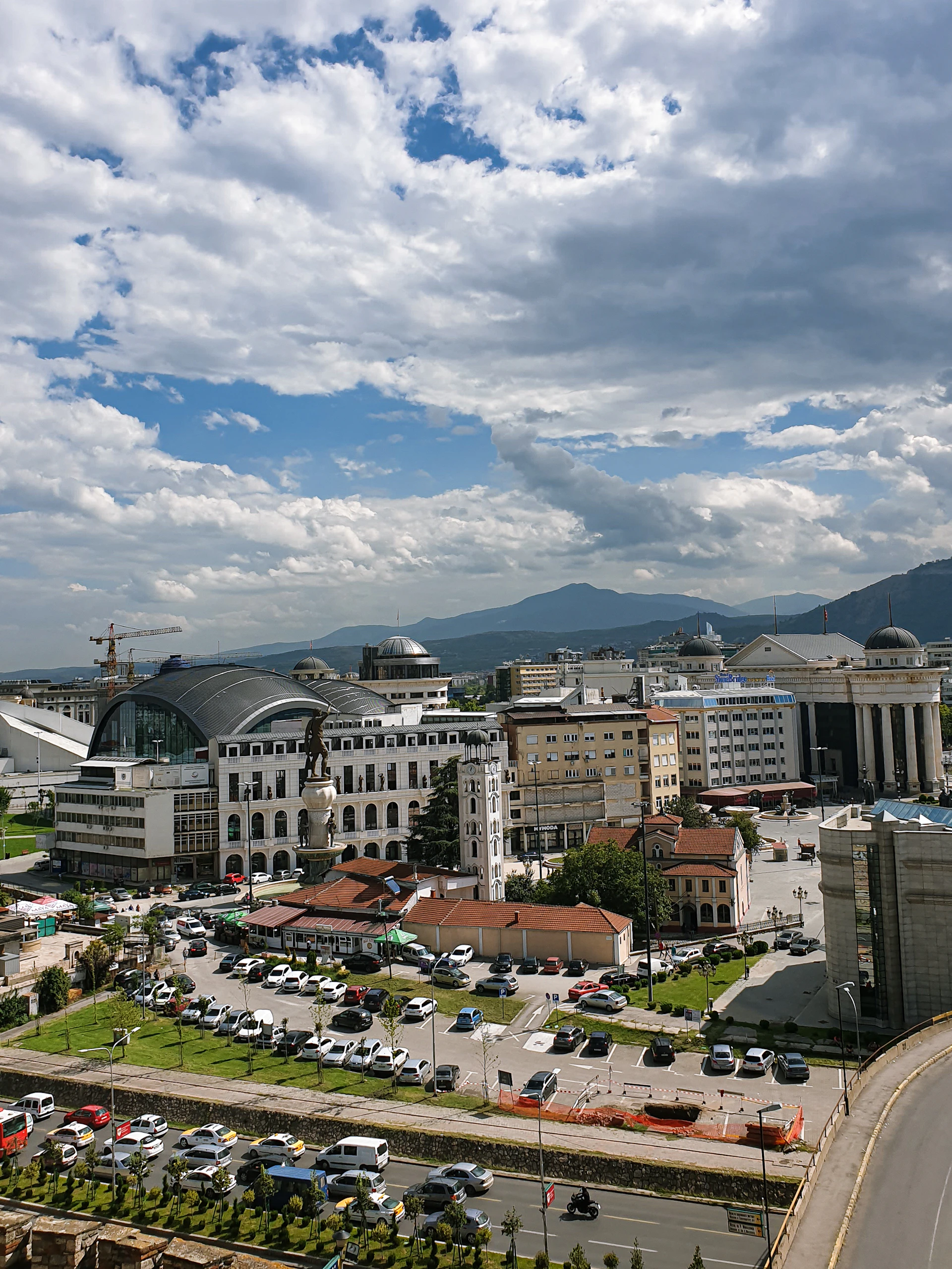white and brown concrete buildings under white clouds and blue sky during daytime