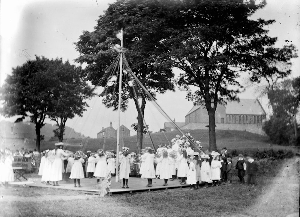 grayscale photo of people standing near trees