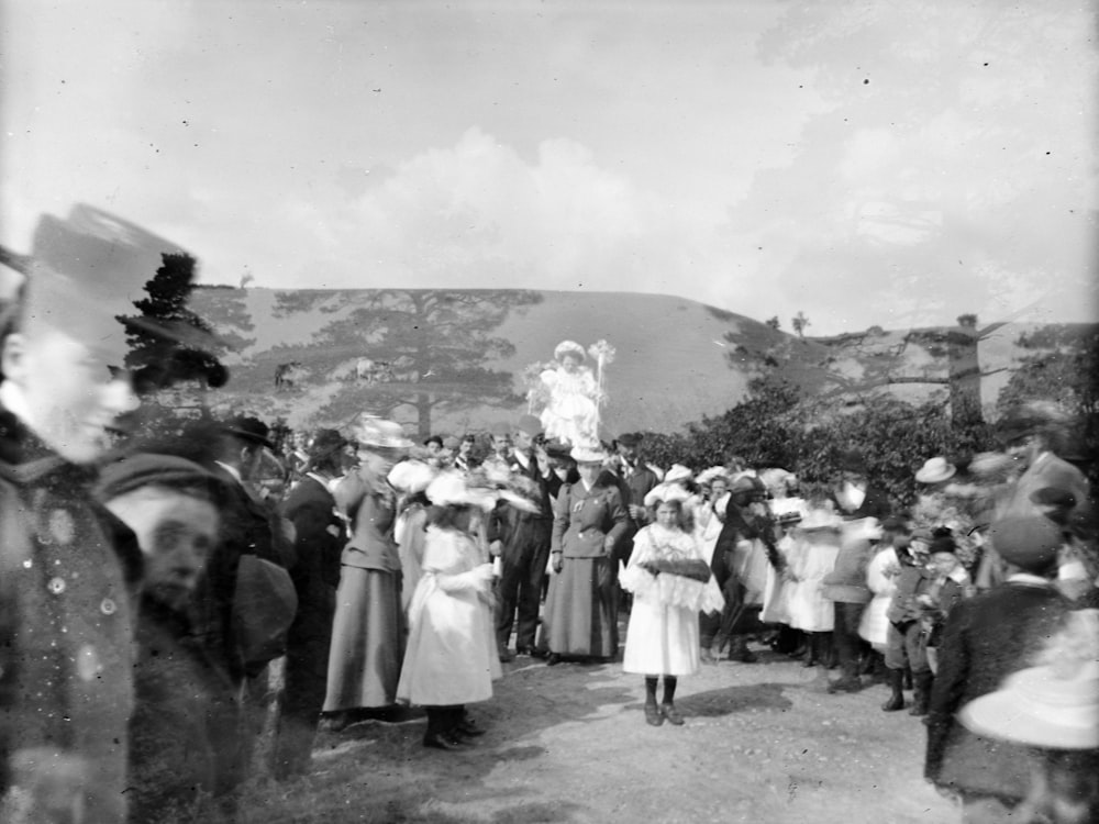 foto em tons de cinza de pessoas em pé no campo