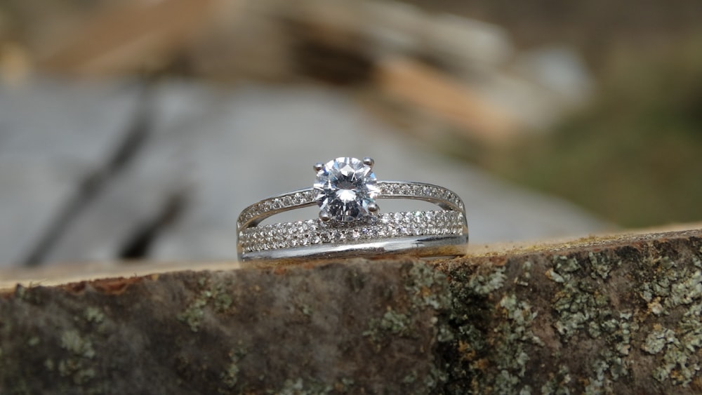 silver diamond ring on gray rock