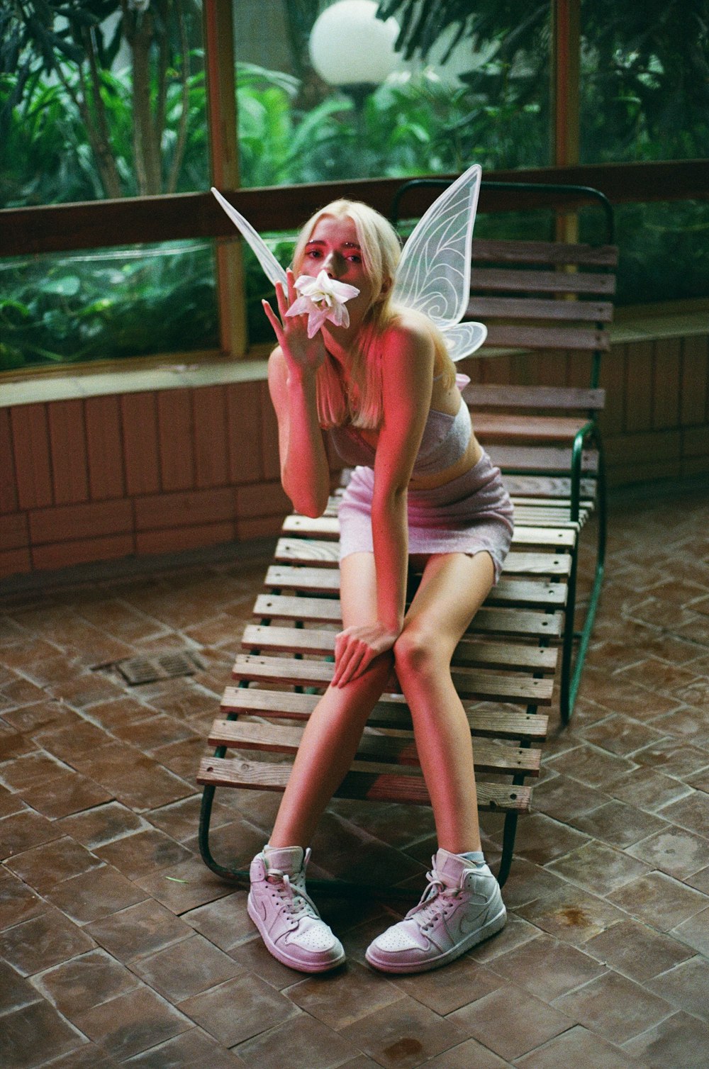 woman in pink tank top sitting on brown wooden bench