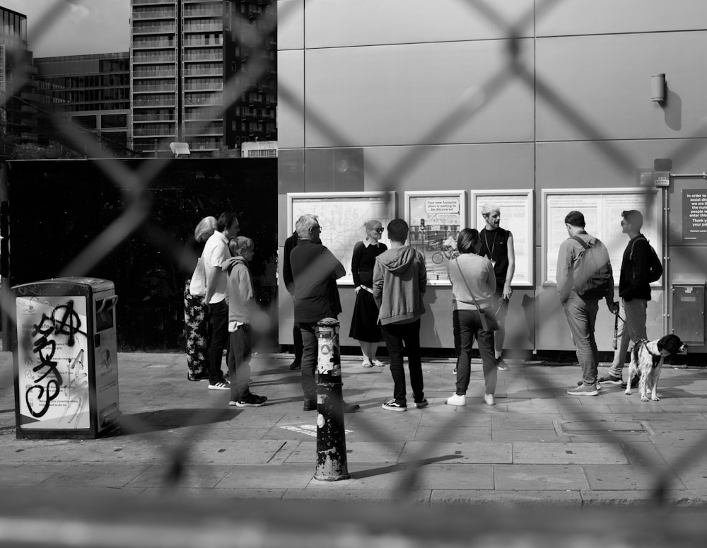 grayscale photo of people walking on sidewalk