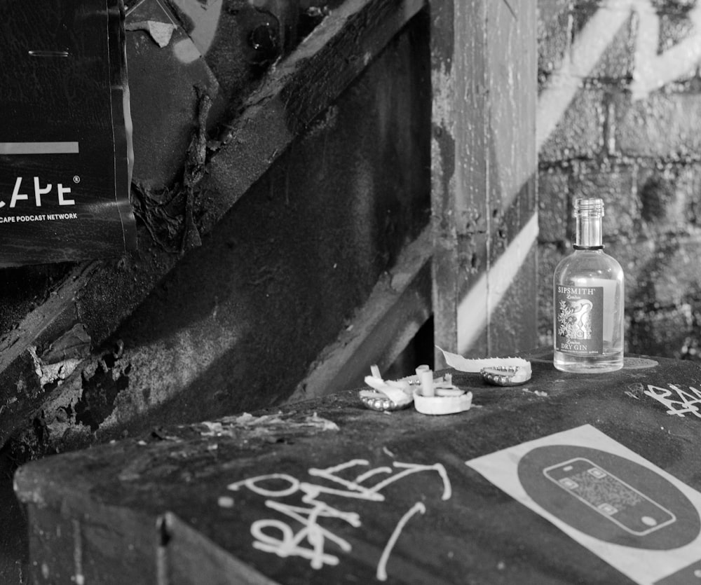 grayscale photo of coca cola bottles on concrete wall