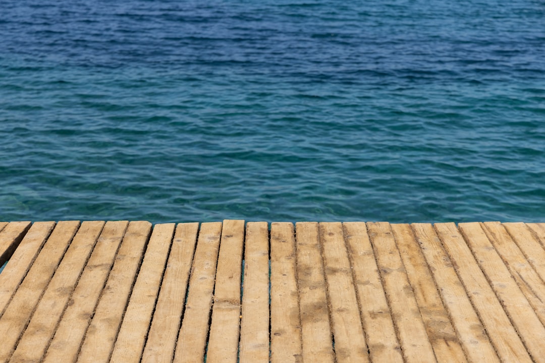 brown wooden dock on blue sea during daytime