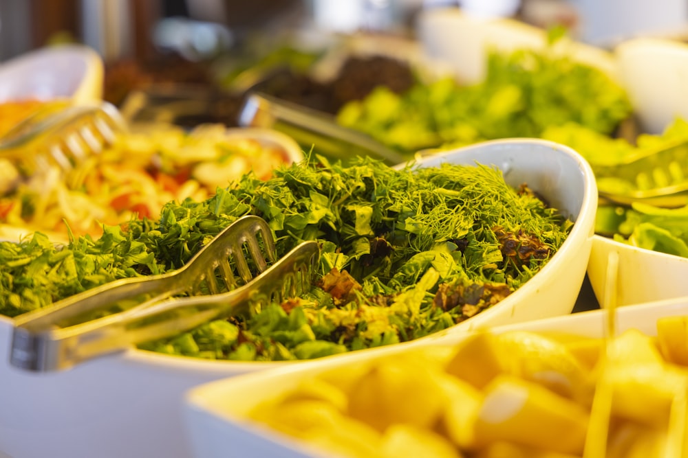 yellow pasta with green leaves in white ceramic bowl