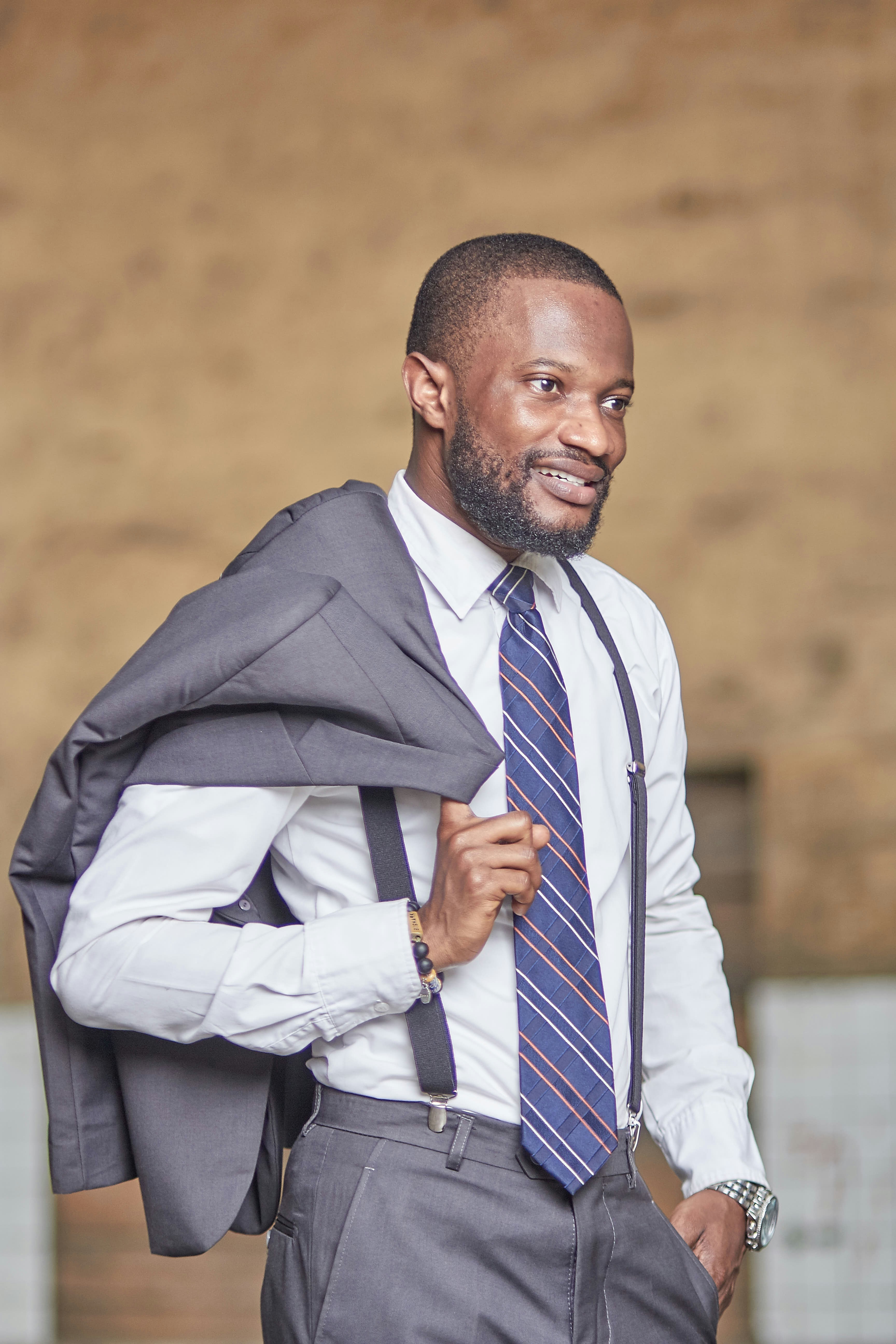 man in black suit jacket and white and blue striped dress shirt