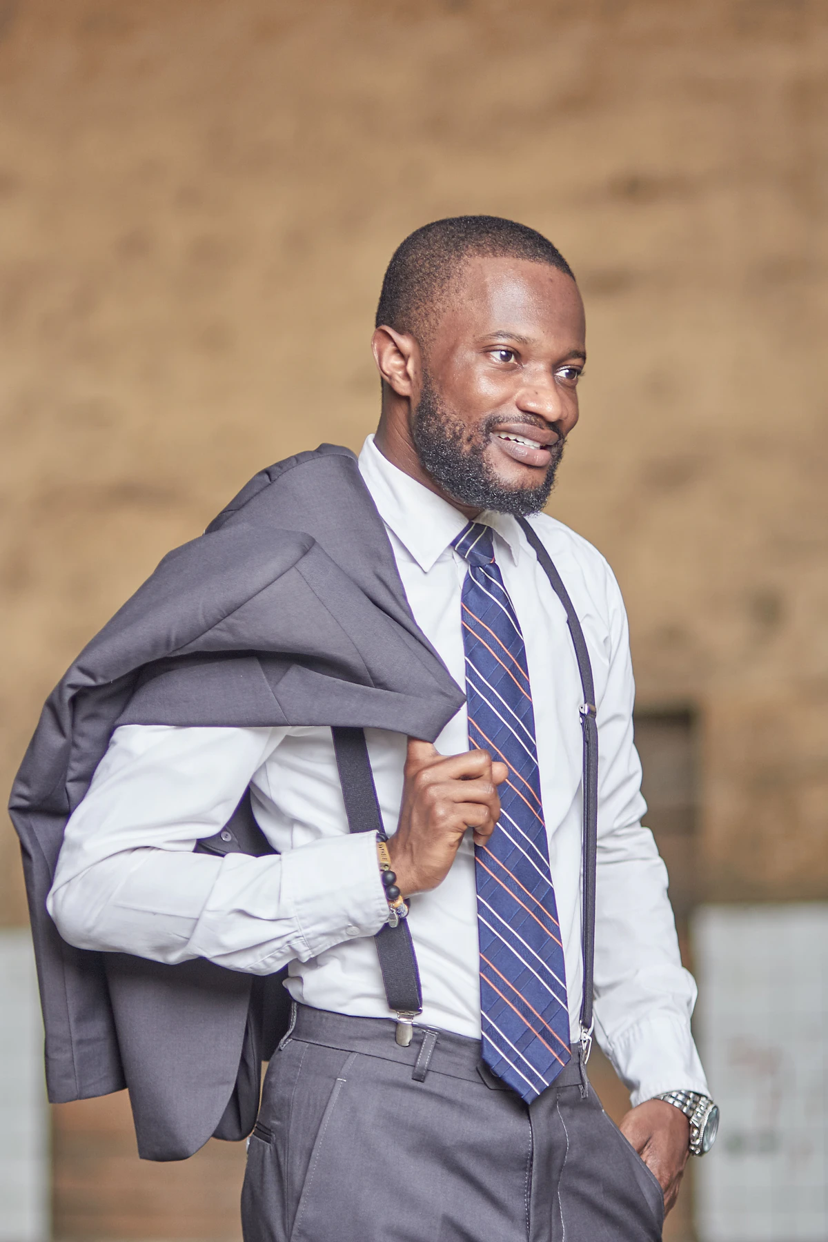 Man in black suit jacket and white and blue striped dress shirt