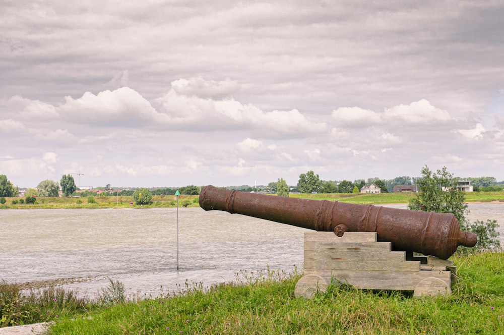 brown metal pipe on green grass field under white clouds during daytime