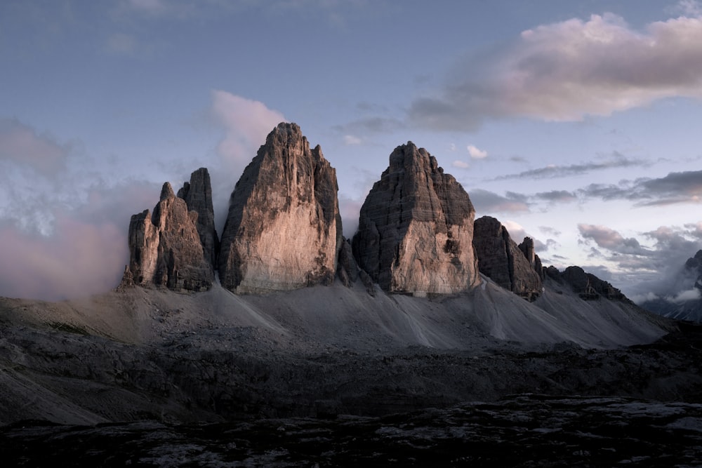 Brauner felsiger Berg unter weißen Wolken während des Tages