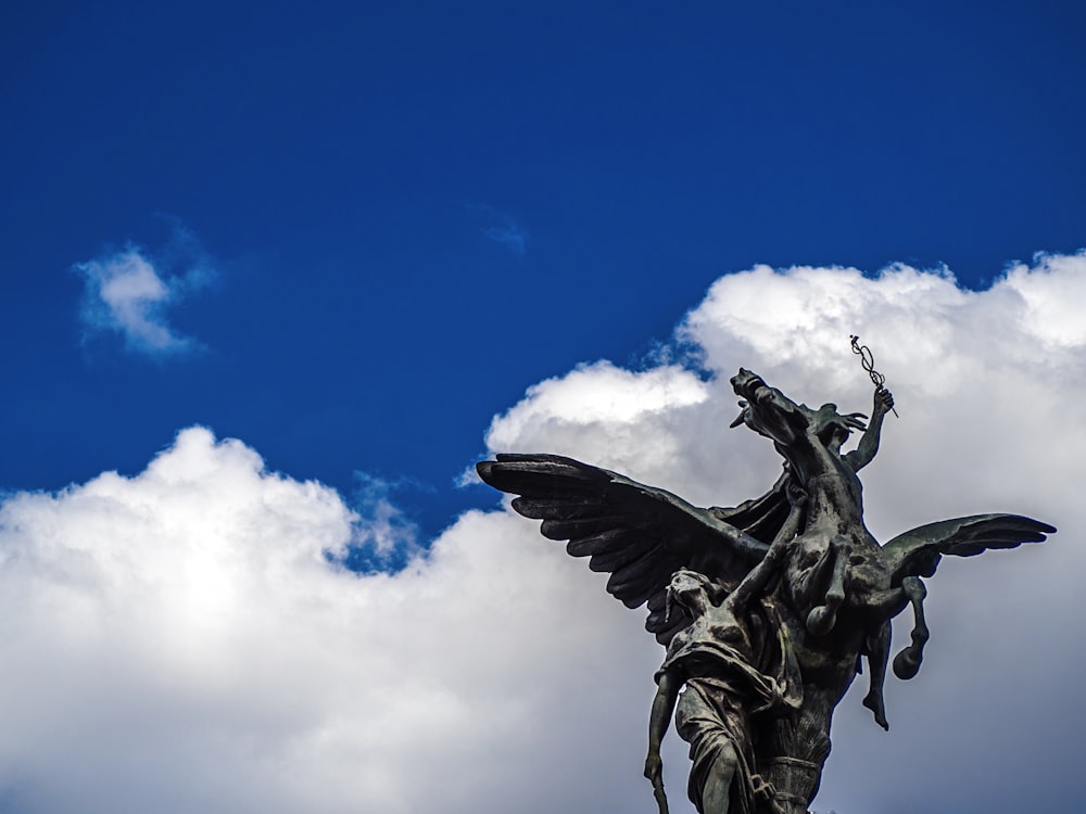 black angel statue under blue sky during daytime