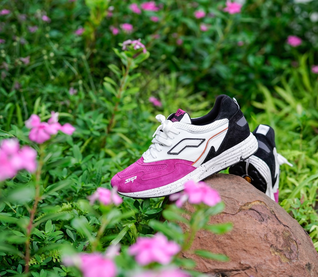 purple and white nike athletic shoes on brown rock