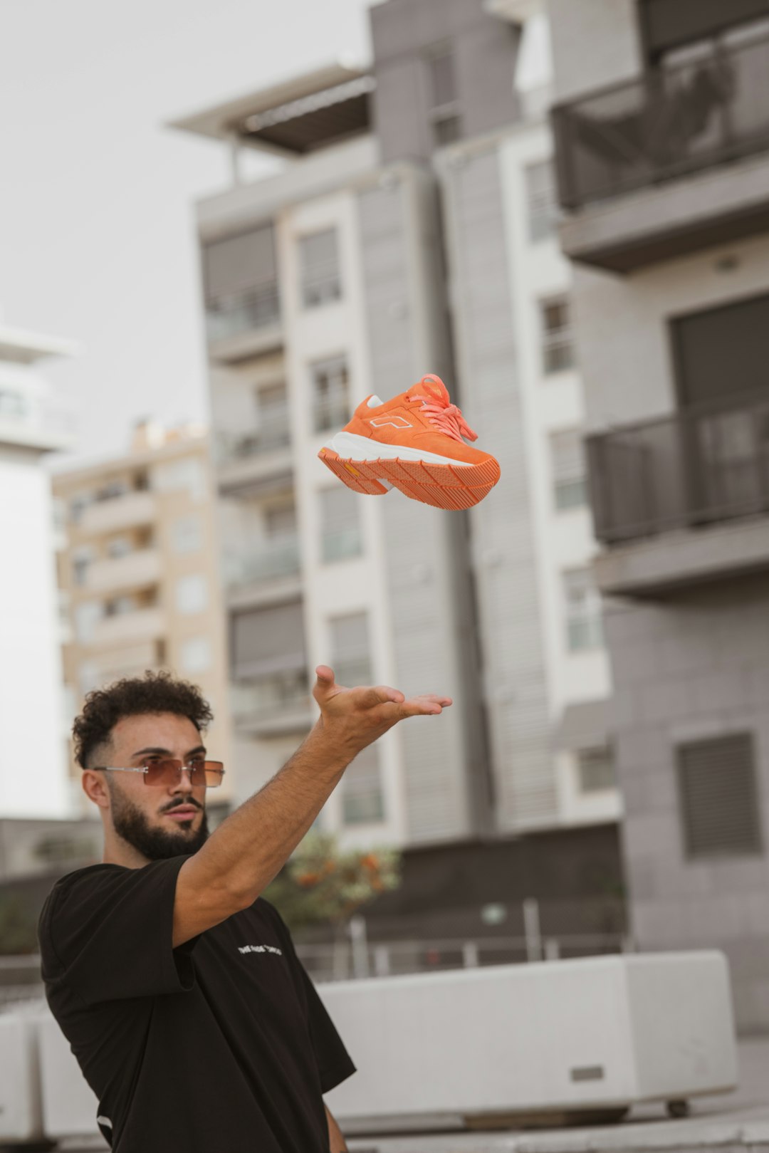 man in black crew neck shirt holding orange heart balloon