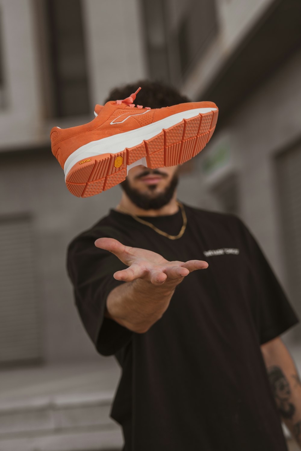 man in black crew neck t-shirt wearing orange and white knit cap