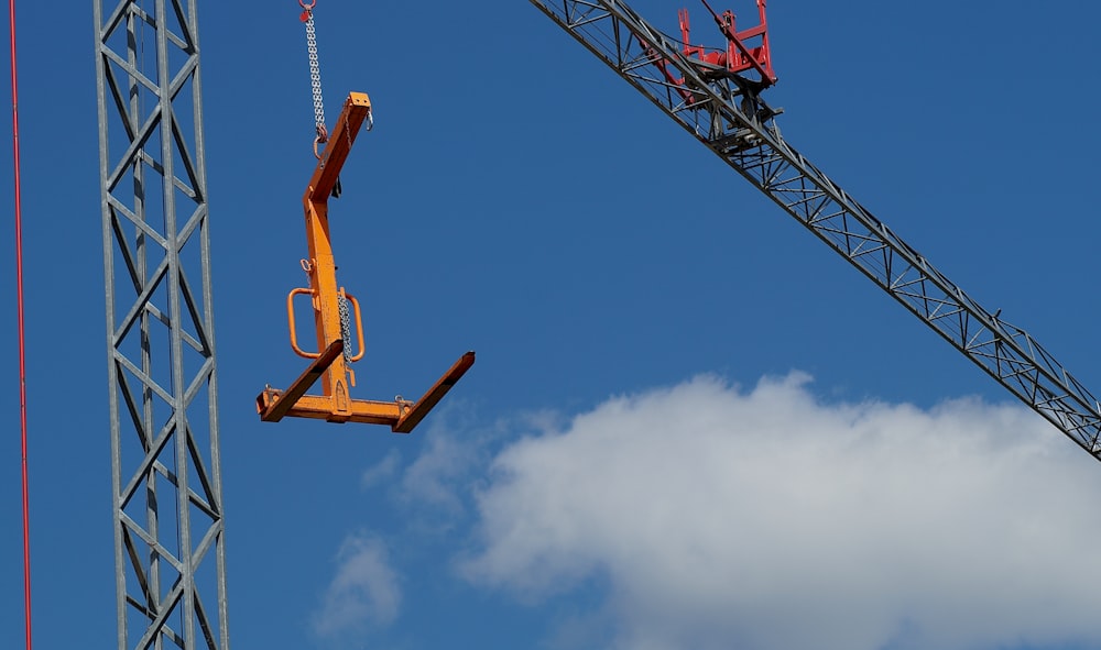 orange metal crane under blue sky