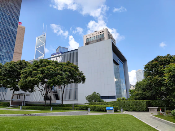 A panoramic view of a modern mixed-use development showcasing sleek architectural lines and lush landscaping under a clear sky.