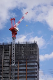 red crane near gray building during daytime