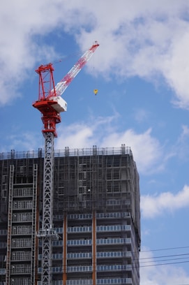 red crane near gray building during daytime
