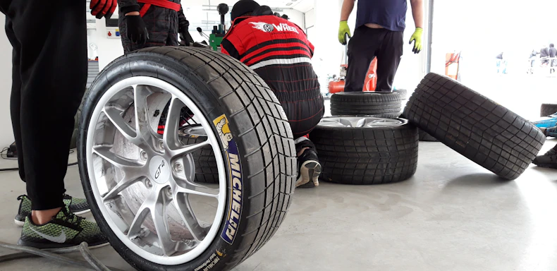 Close-up of a mechanic changing a tire at a garage with tools around.