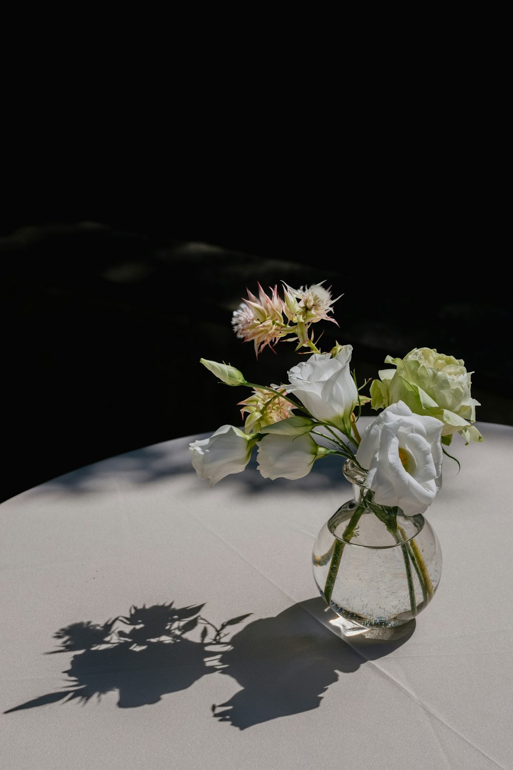 white and yellow flowers on clear glass vase