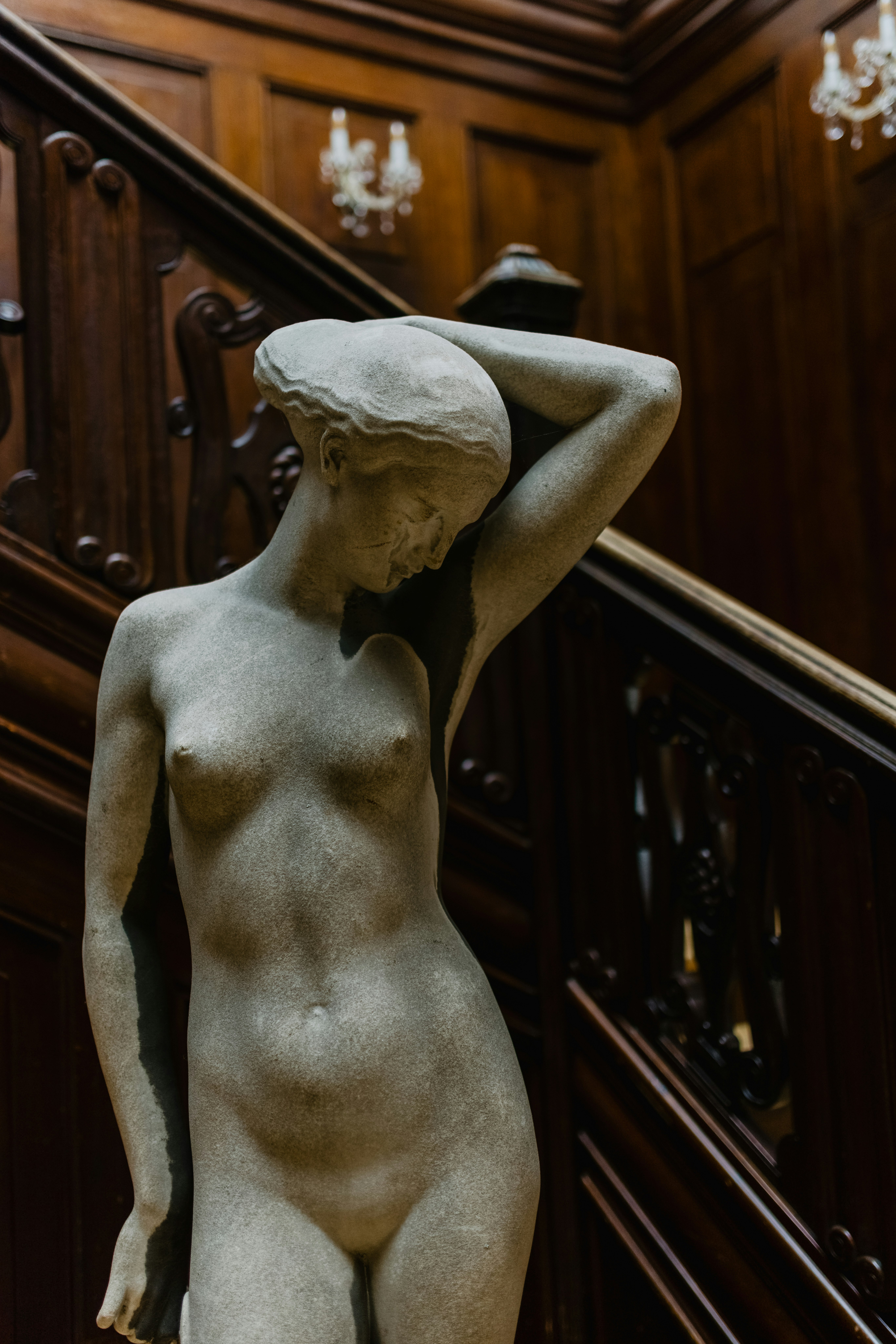 woman statue in front of brown wooden wall