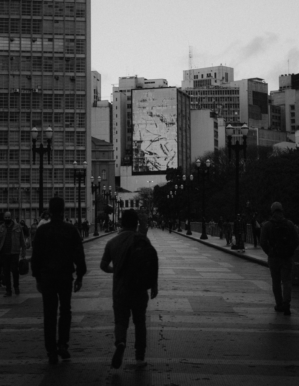 grayscale photo of people walking on sidewalk