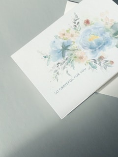A close-up of a heartfelt thank-you card decorated with flowers.