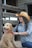 a woman in a cowboy hat petting a dog