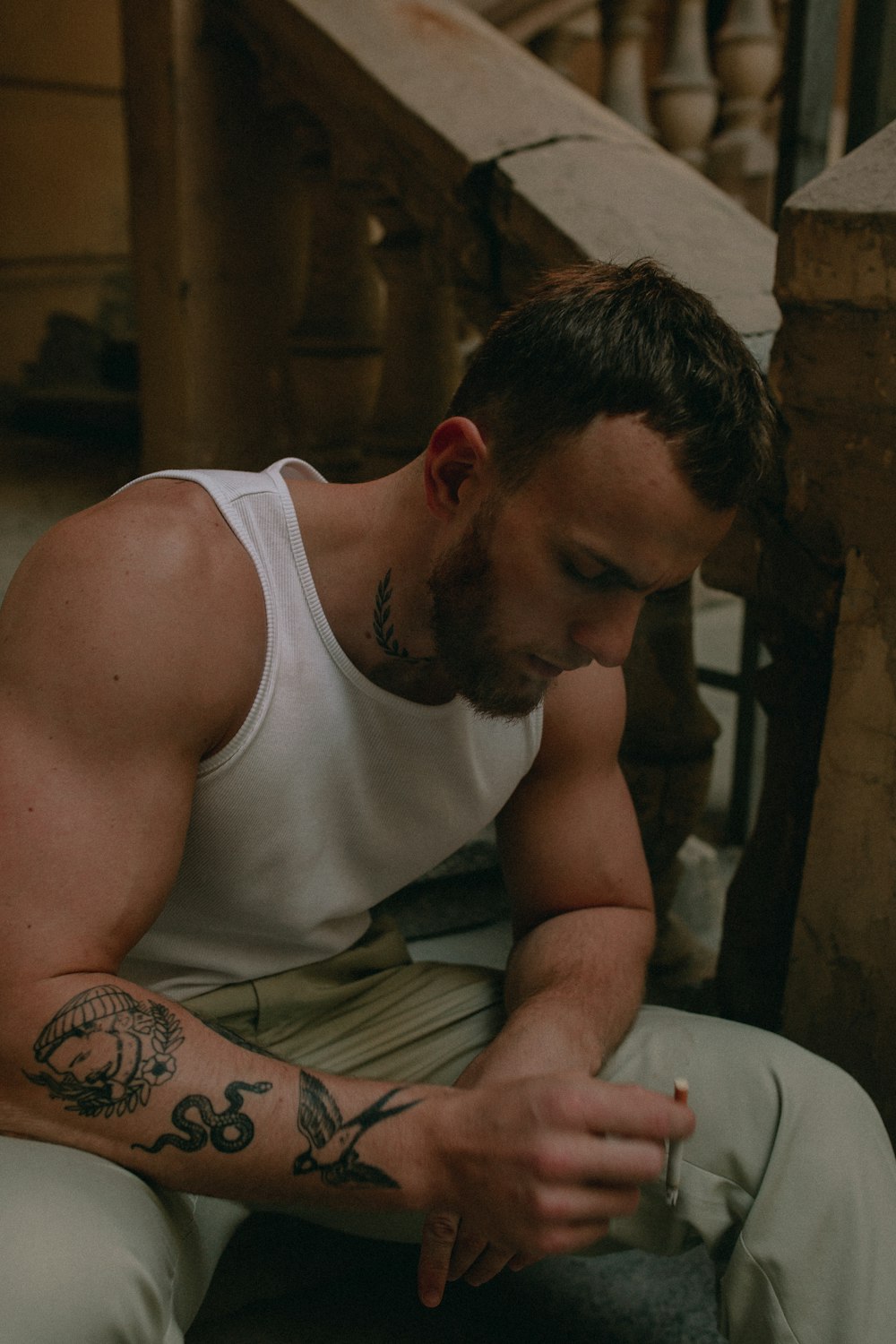 man in white tank top sitting on chair