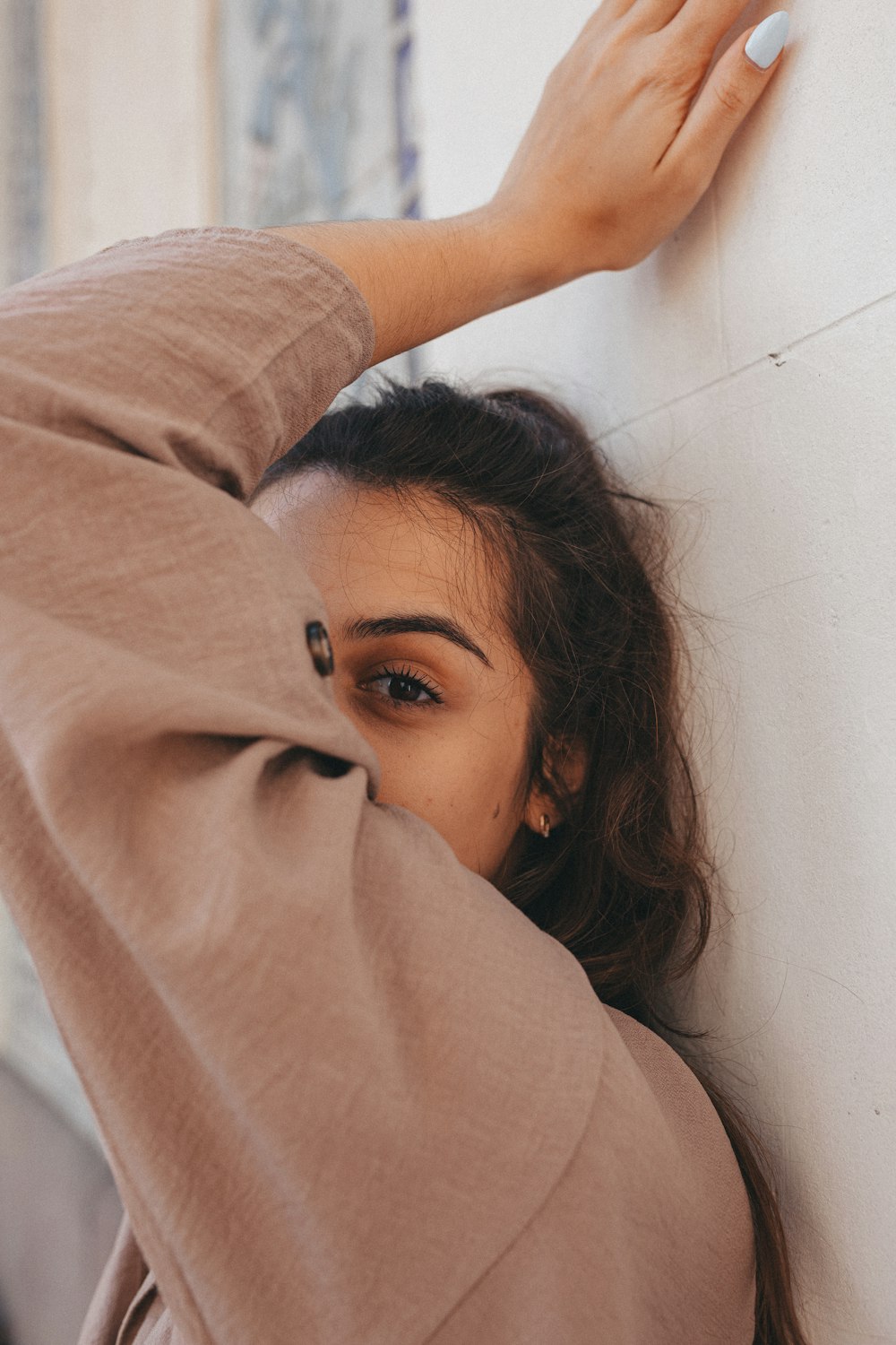 woman in brown long sleeve shirt lying on white ceramic floor tiles