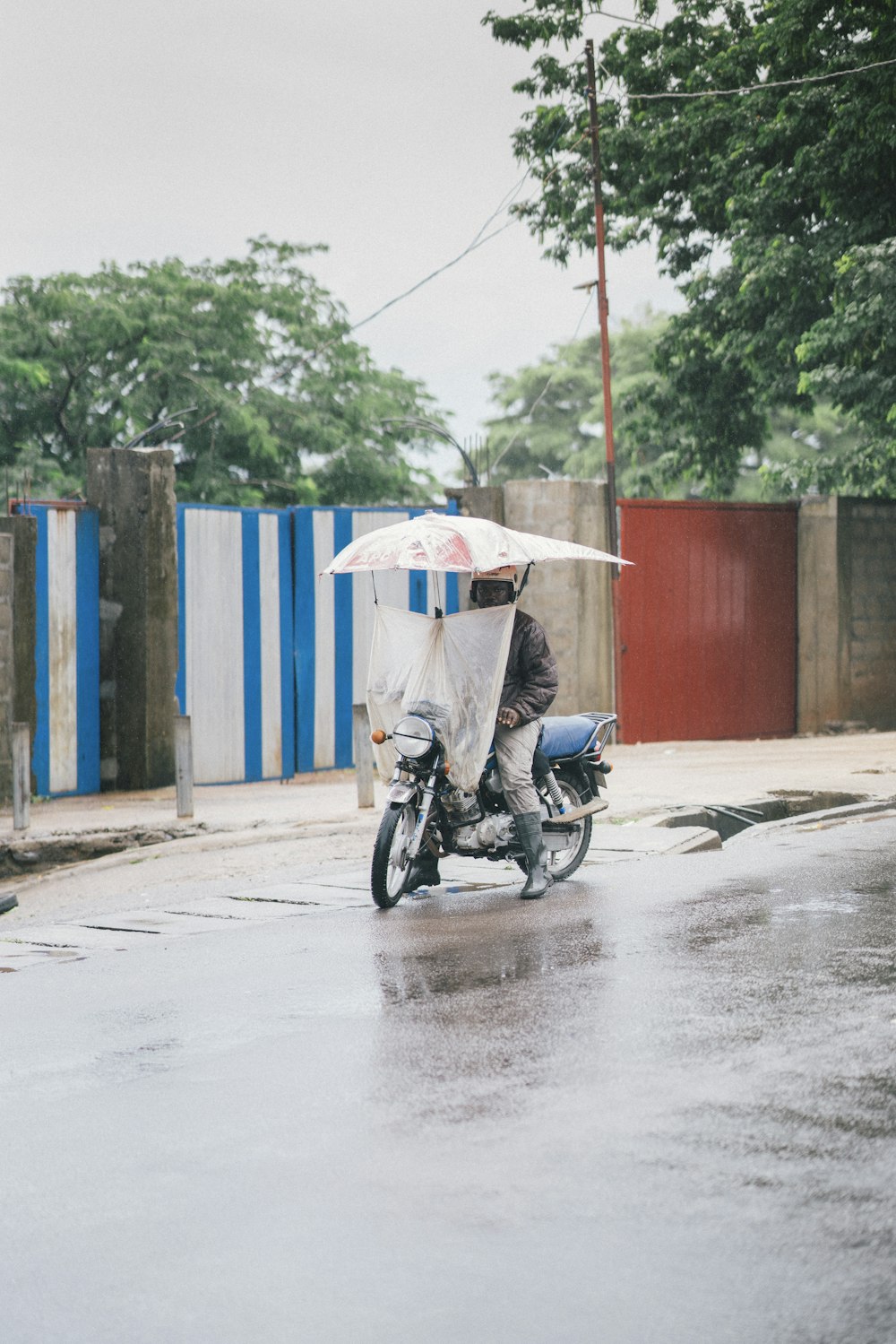 man in black motorcycle with white umbrella on his head