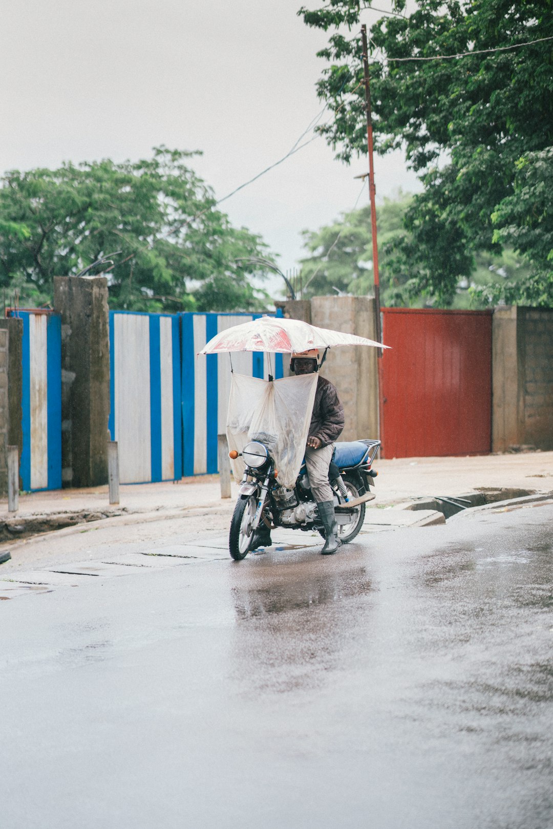 man in black motorcycle with white umbrella on his head