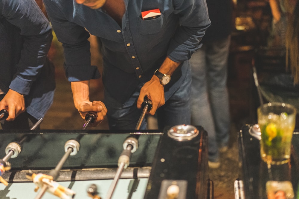 man in blue long sleeve shirt holding black metal tool