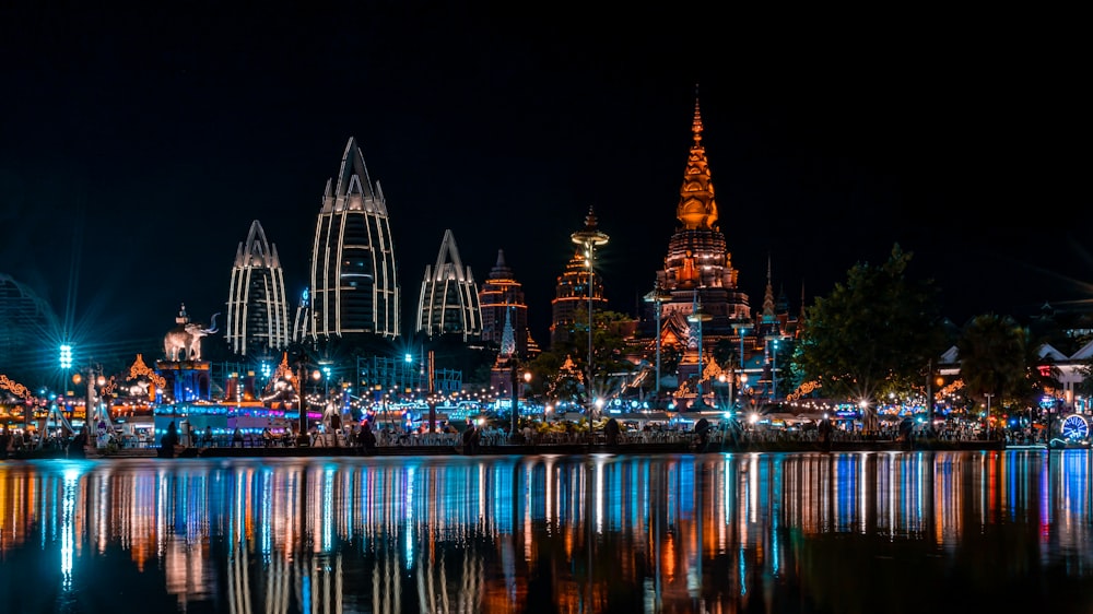 Edificio iluminado cerca del cuerpo de agua durante la noche