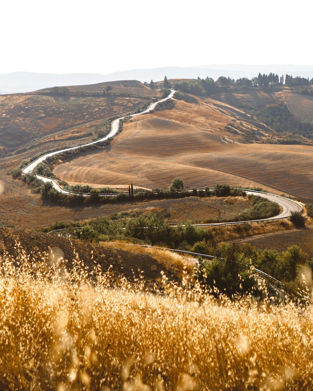 aerial view of road in the middle of brown grass field during daytime