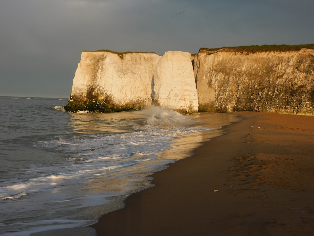 brown rock formation on sea water during daytime