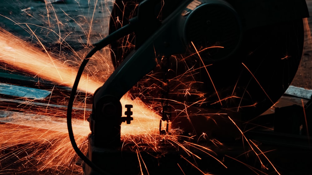 black metal pipe near body of water during sunset